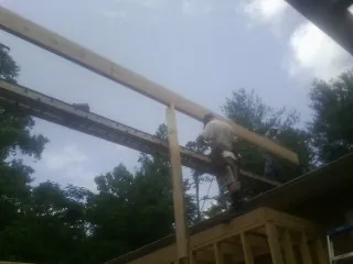 Carpenter setting a ridge beam over a new addition frame — Ice Dam Removal by Roofing Brothers in Mica