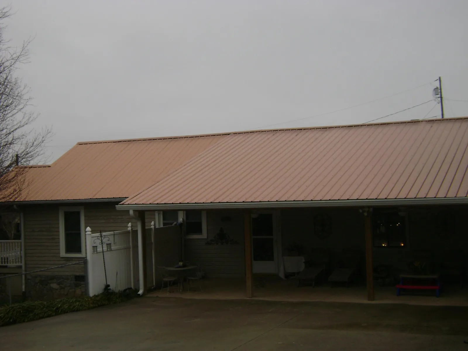 Copper toned metal roof over a wide covered patio in Mica